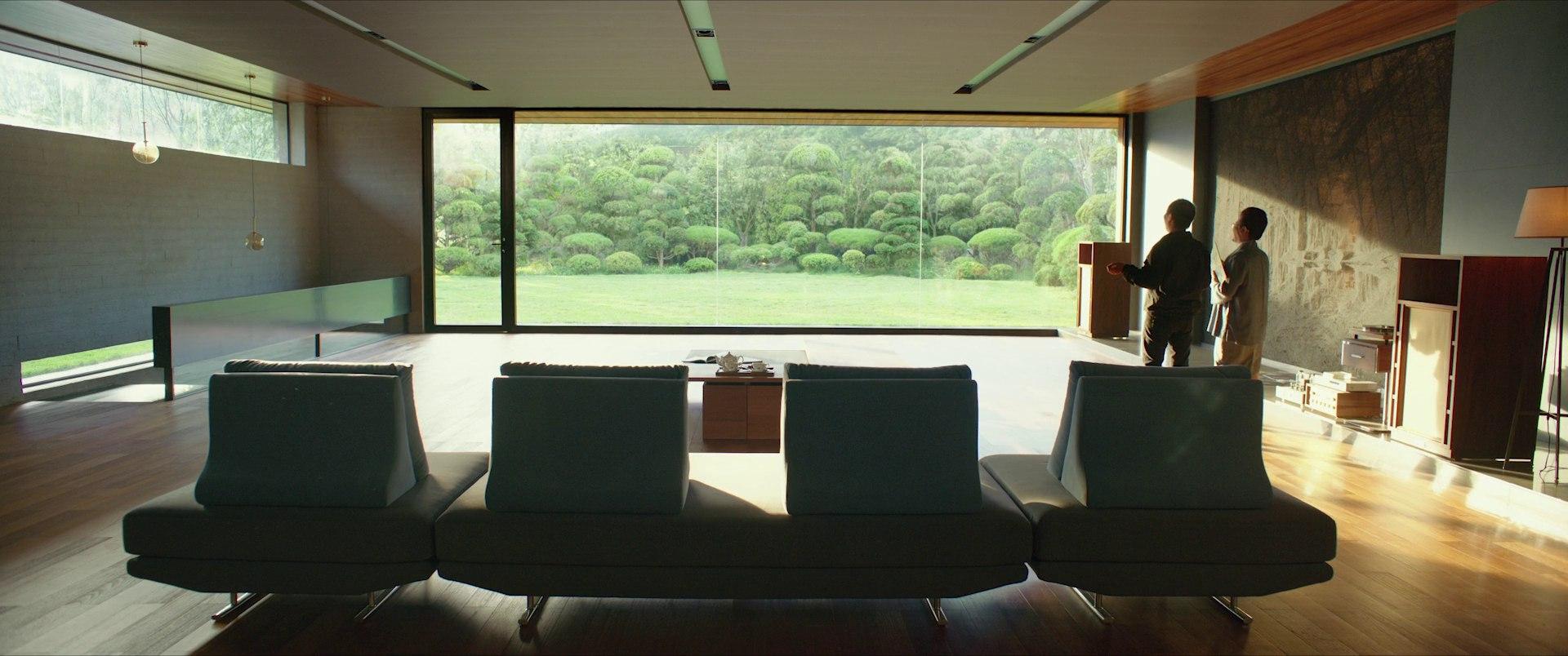 The Park family's vast, pristine living room with floor-to-ceiling windows overlooking a manicured garden